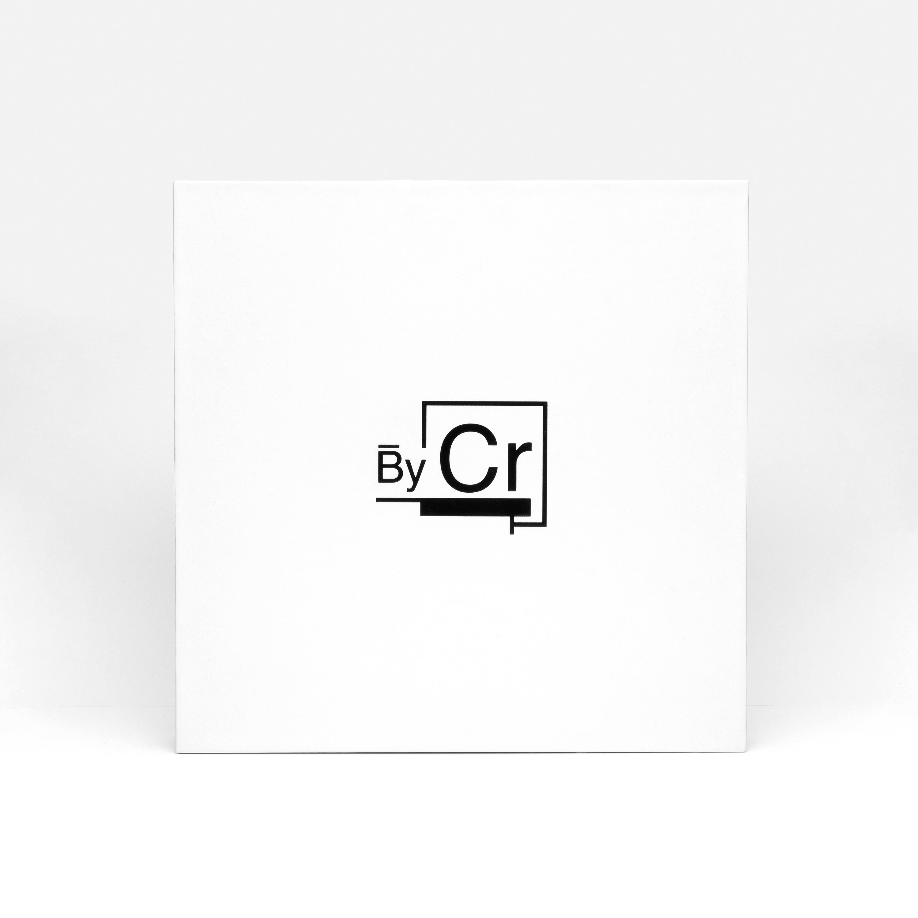 Contemporary 'By Cr' logo on a pristine white square box.